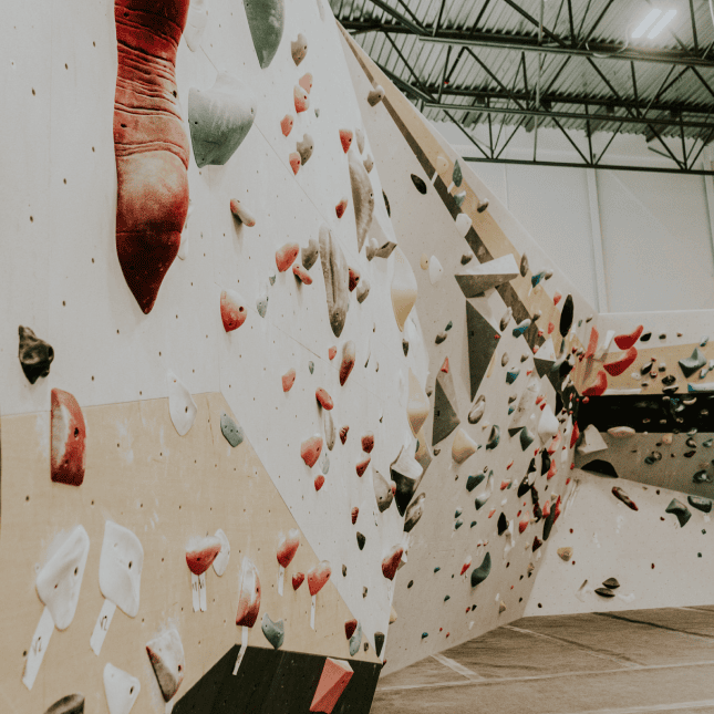 Close-up view of climbing holds and textured wall surfaces in a gym.
