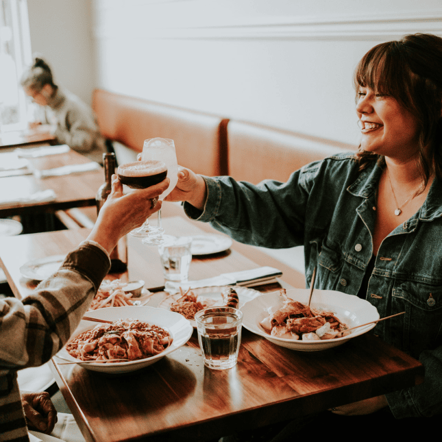 Two people eating at a restaurants with drinks