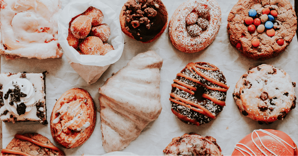Assortment of decorated donuts arranged neatly on a light background.