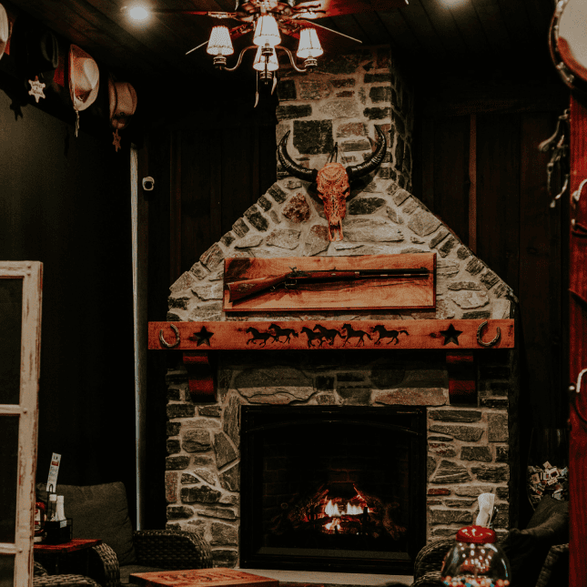 A rustic wood-fired oven with pizza inside and a warm glowing fire.