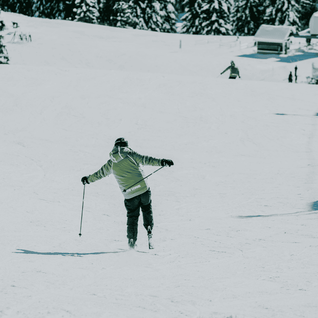 A skier gliding downhill on a snowy slope