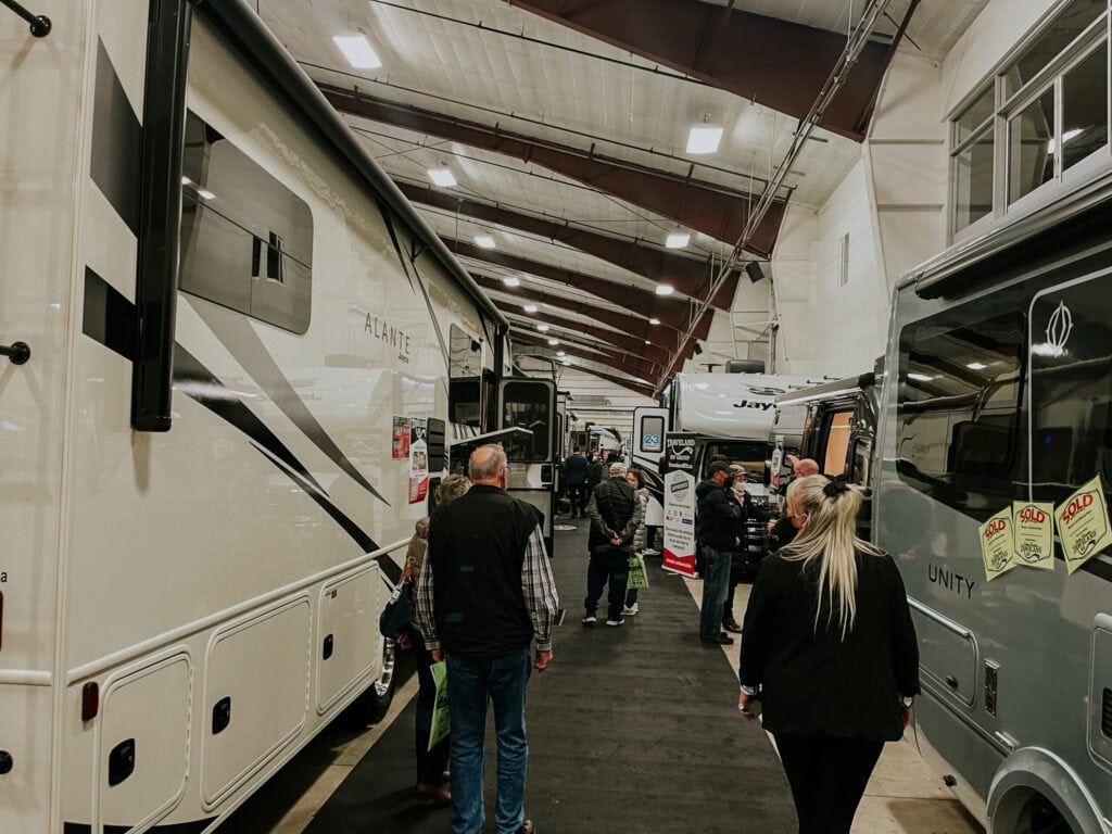 people at an rv show, looking through various rv