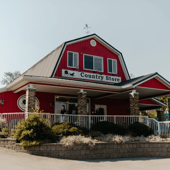 Red barn-style market building under a blue sky.