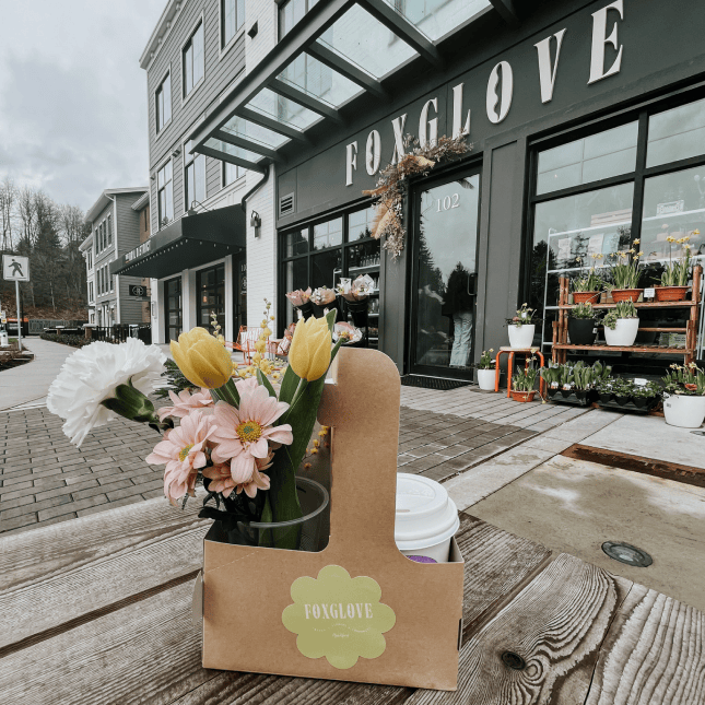 Flower shop storefront with tulips displayed outside.