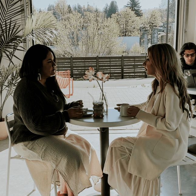 Two women having coffee at a café table.