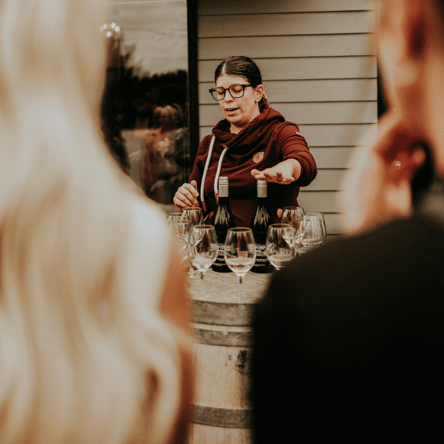 Person speaking during a wine tasting experience.