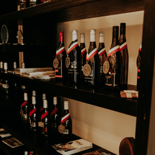 Wine bottles displayed on a tasting room wall.
