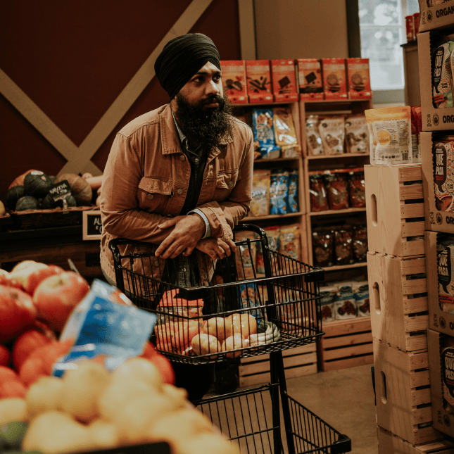 A person inside a produce aisle in a farmers market.