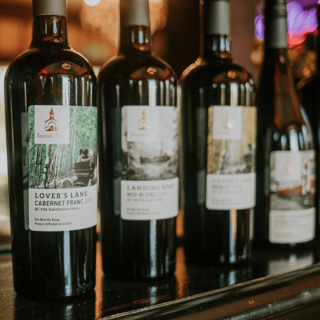 Wine bottles displayed on a tasting room shelf.