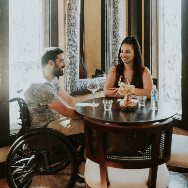 Two people seated at a table inside a winery tasting room.