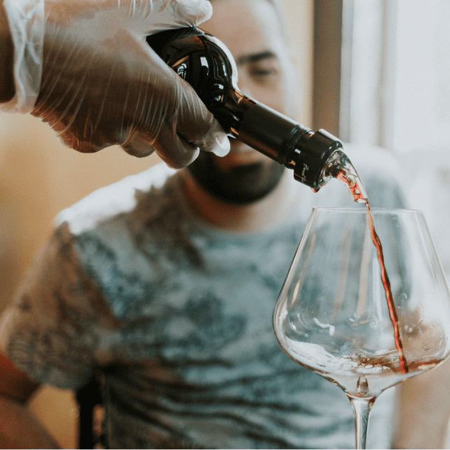 Wine being poured into a glass during a tasting.