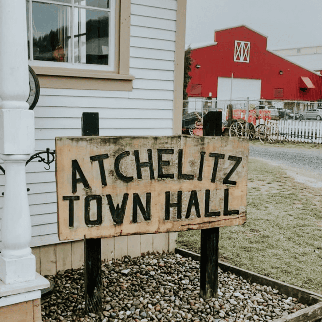 Wooden sign reading “Atchelitz Town Hall” outdoors.
