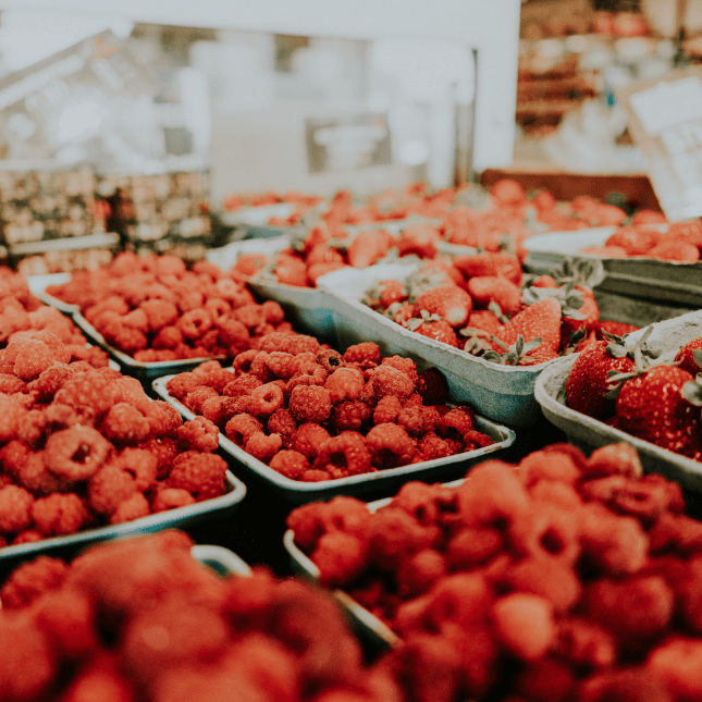 Display of fresh raspberries at a farm stand.