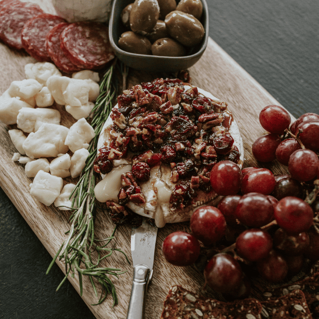 Charcuterie board topped with fruit and spreads.