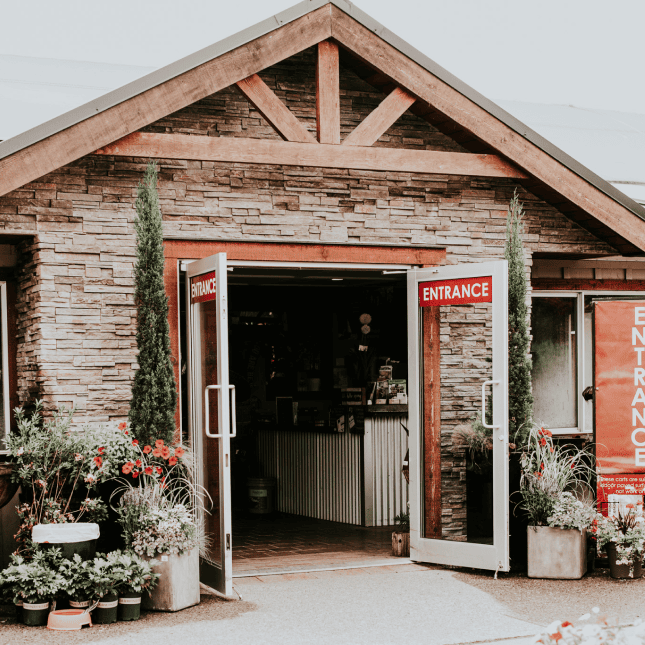 Rustic wooden storefront entrance with flower displays outside.