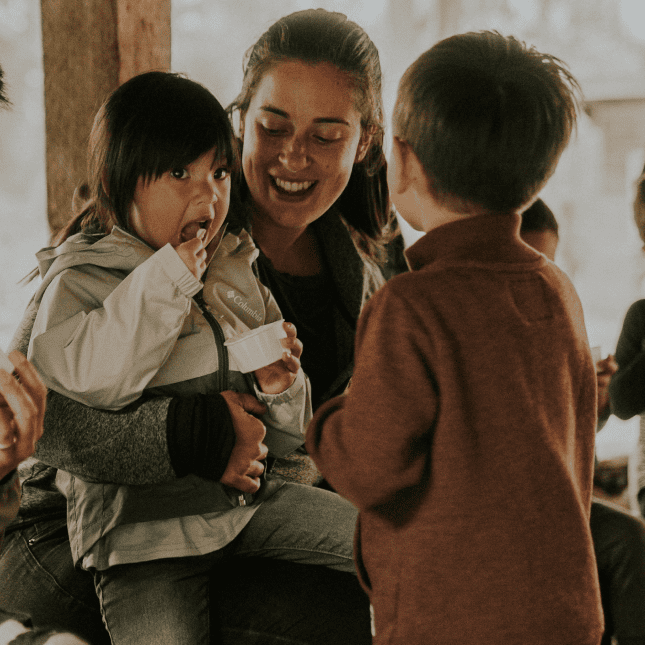 A woman hugging her small children